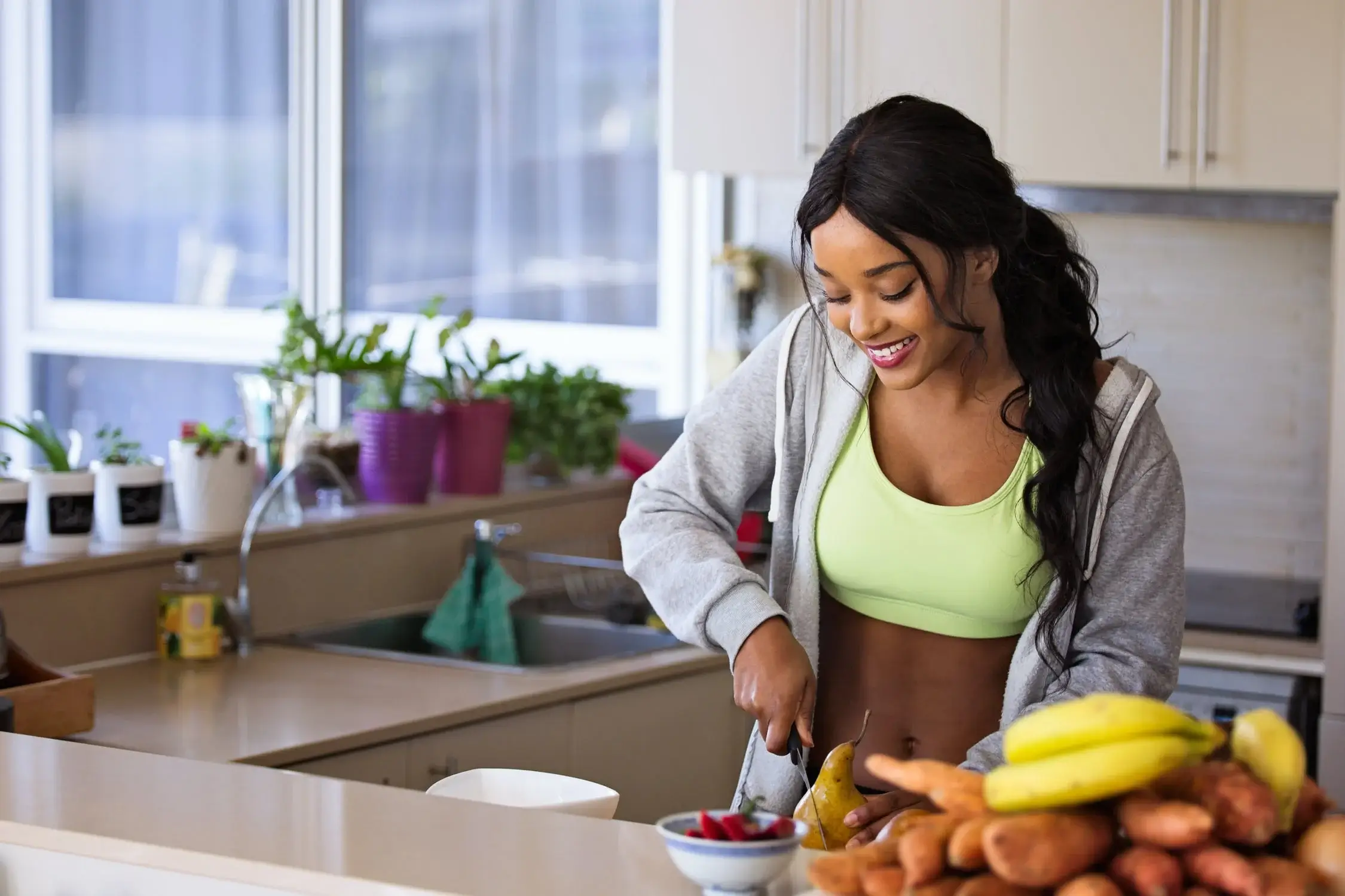 Woman preparing healthy food in a kitchen, promoting wellness and lifestyle choices.