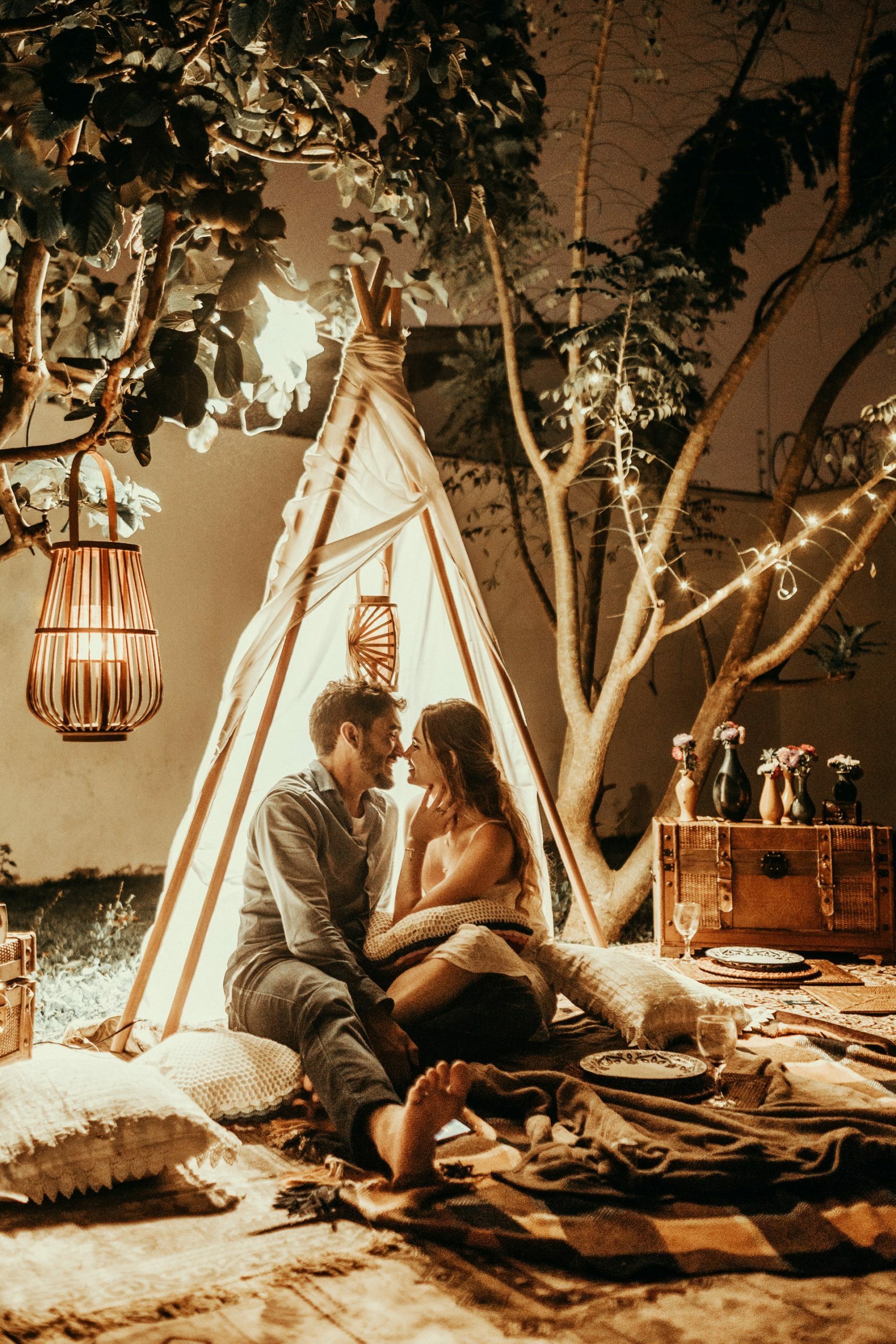 a man and woman sitting under a tree