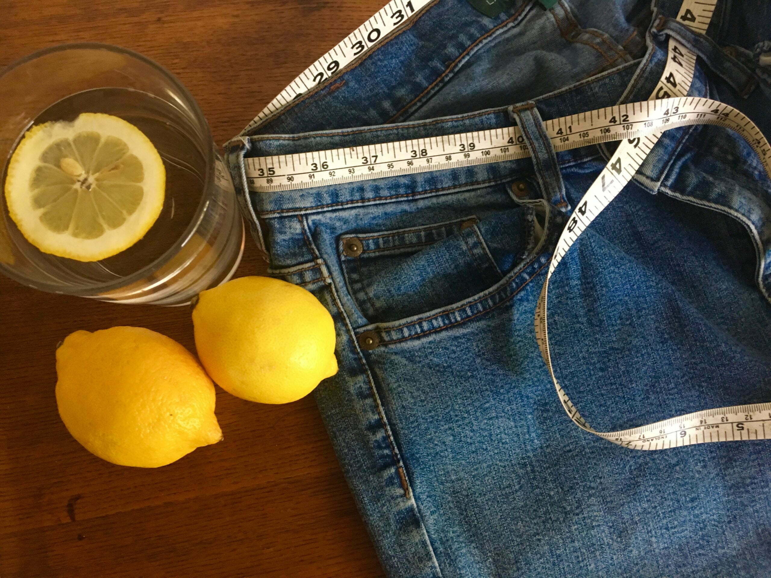 a pair of blue jeans and a white shoe next to lemons