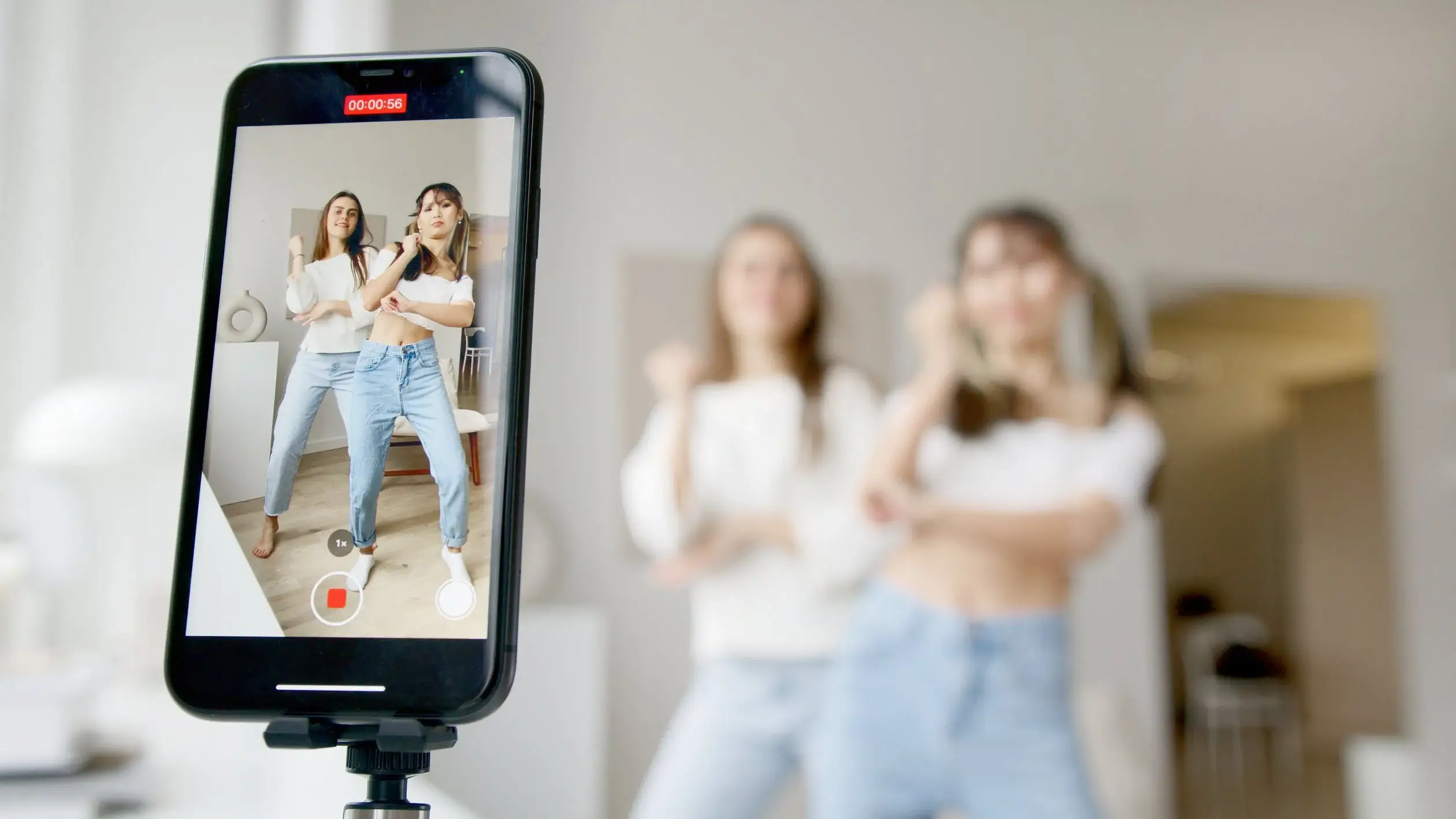 Smartphone displaying TikTok video of young women dancing, lifestyle guide ideas.