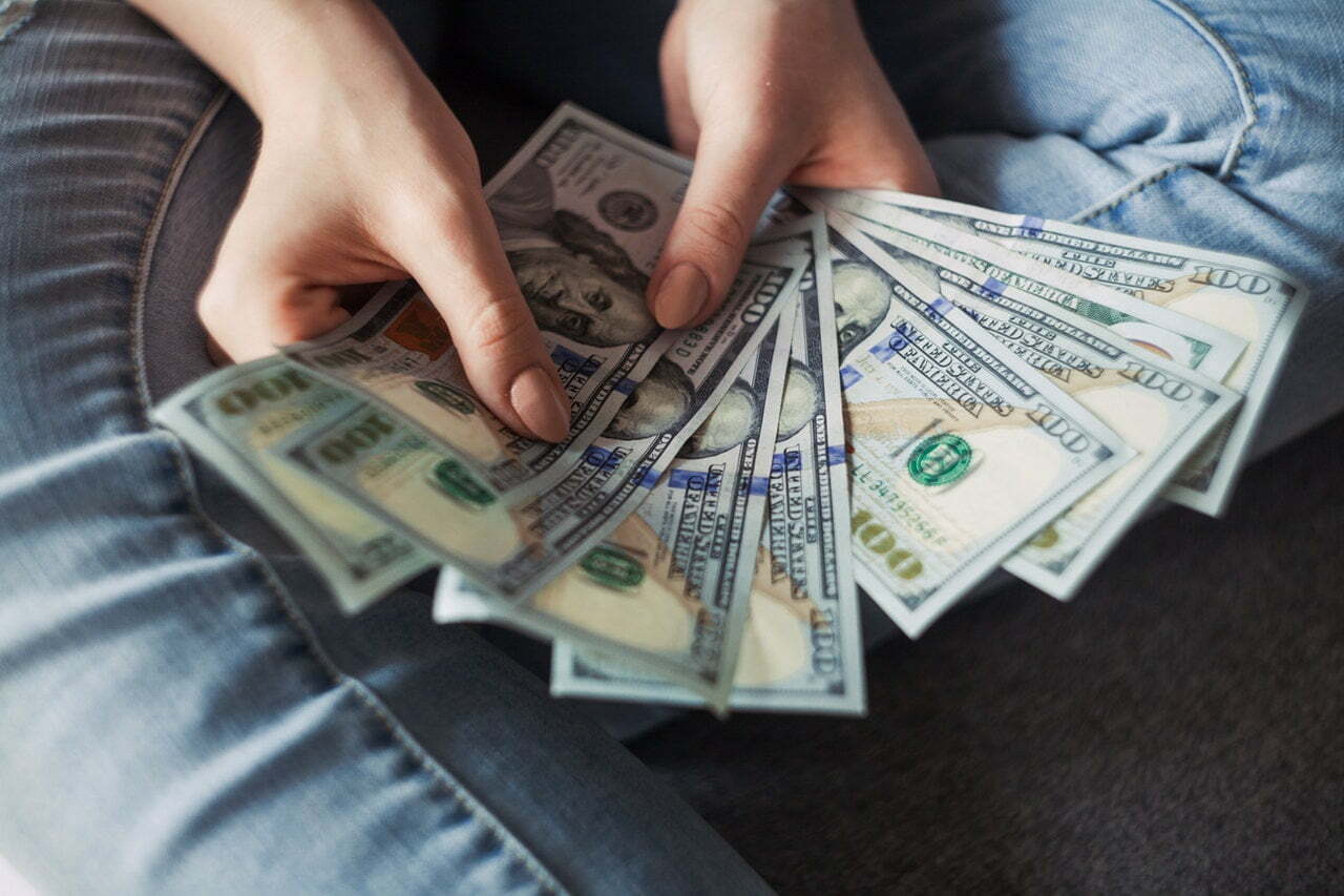 a person holding a stack of paper money
