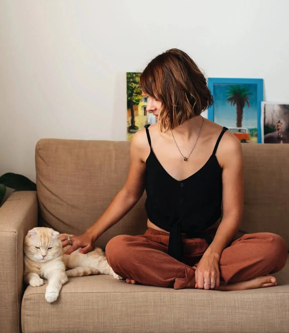 a woman sitting on a couch with a cat