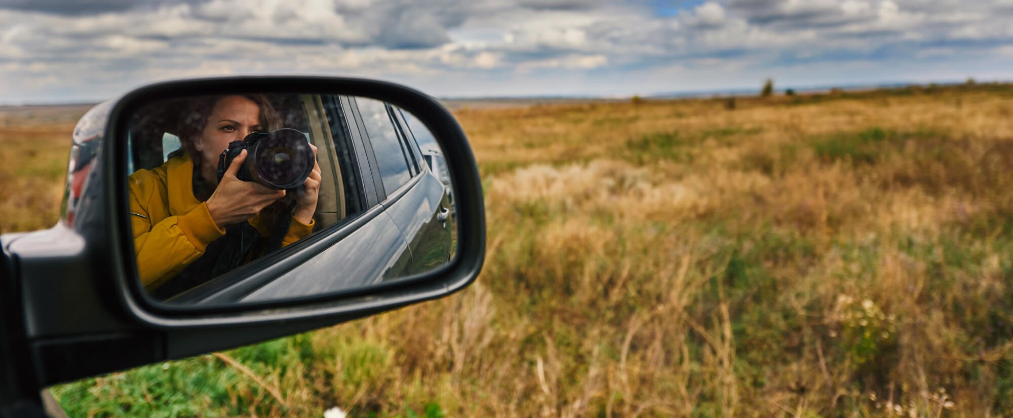 a person in a car looking at a side mirror