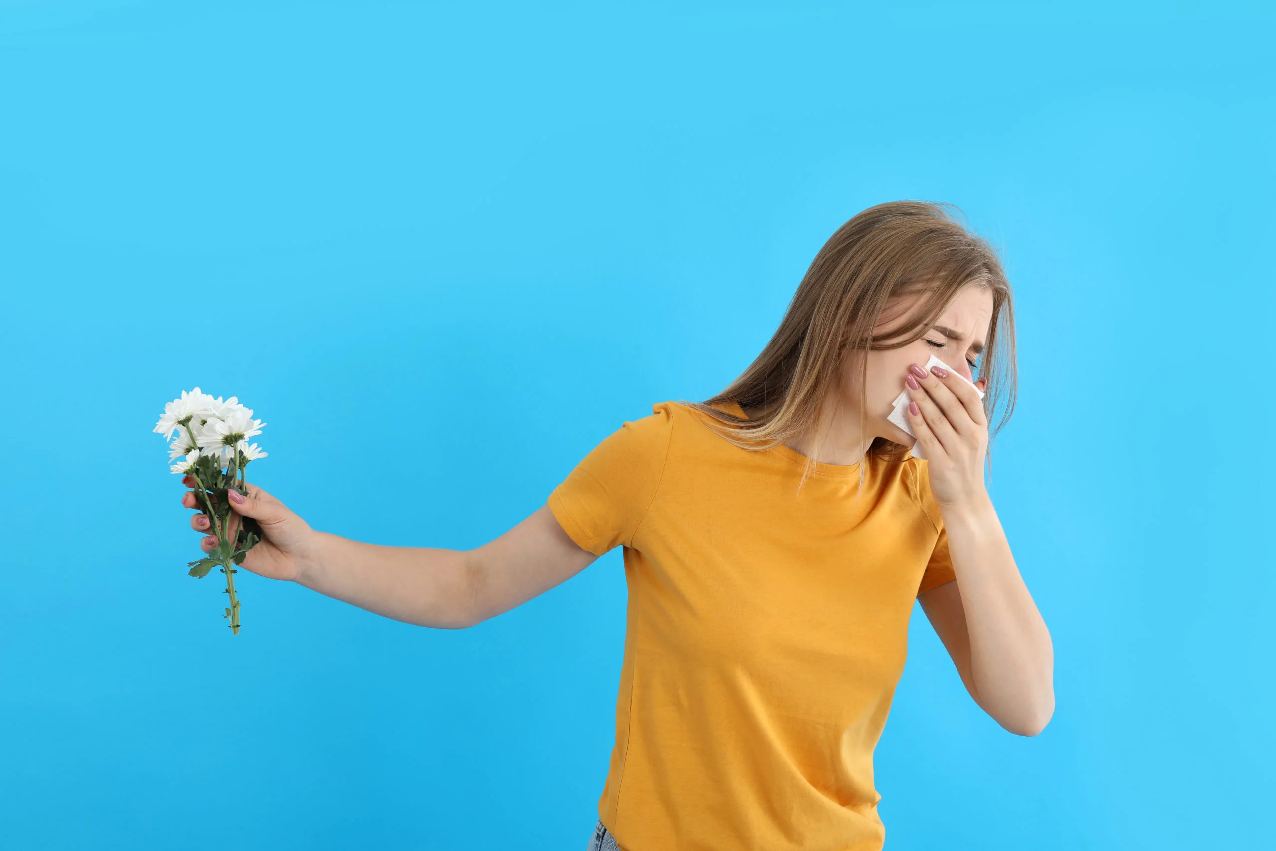 Girl with allergy hold flower on blue background